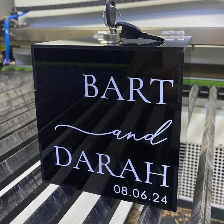 Elegant black acrylic box displaying 'Bart and Darah, 08.06.24' in white cursive font, a chic choice