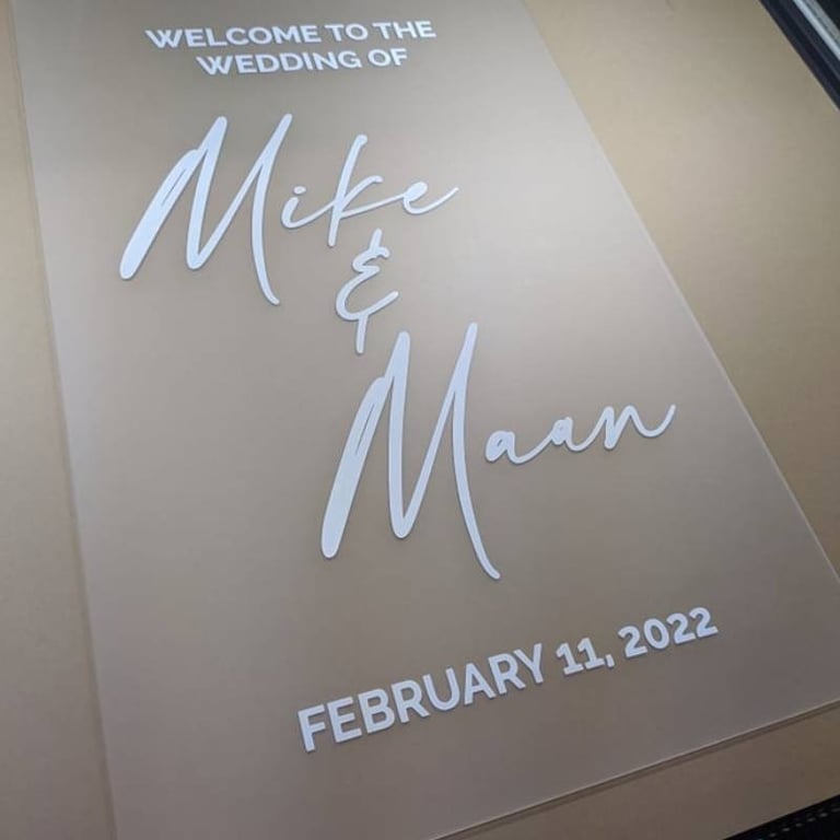 Acrylic wedding welcome sign for Mike and Maan dated February 11, 2022, displayed on a printing bed.