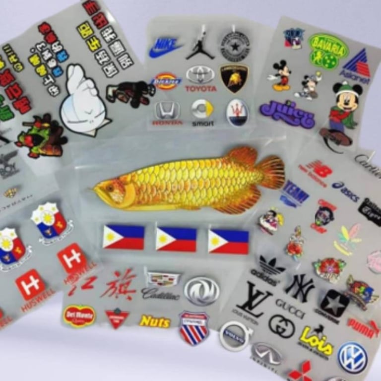Assorted collection of UV DTF printed brand stickers on a transparent sheet.