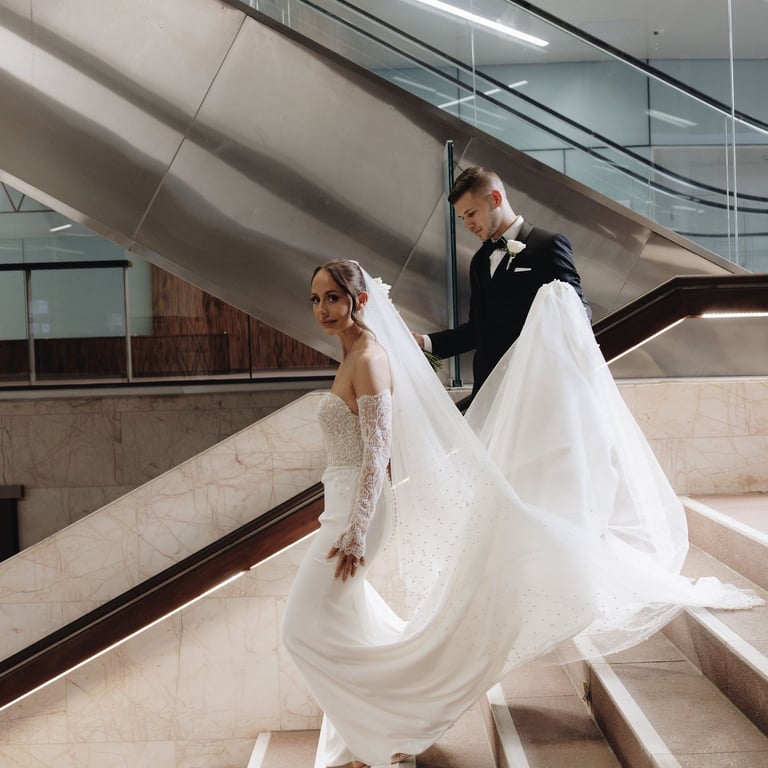 a bride and groom walking down a flight of stairs