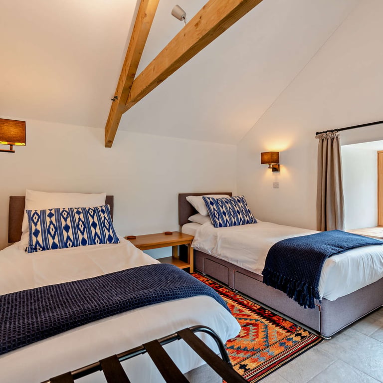 The second bedroom has twin beds and views out over the valley and courtyard, a perfect holiday cottage for groups.