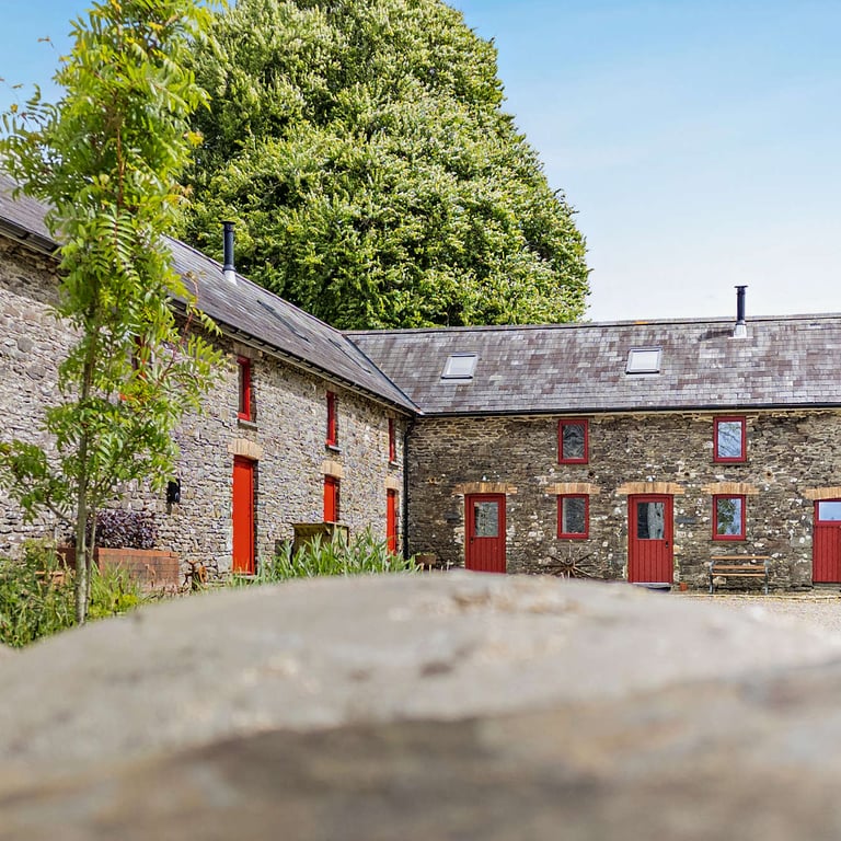 Our holiday cottages in Carmarthenshire are formed within a converted stone barn and have bright red windows and doors.
