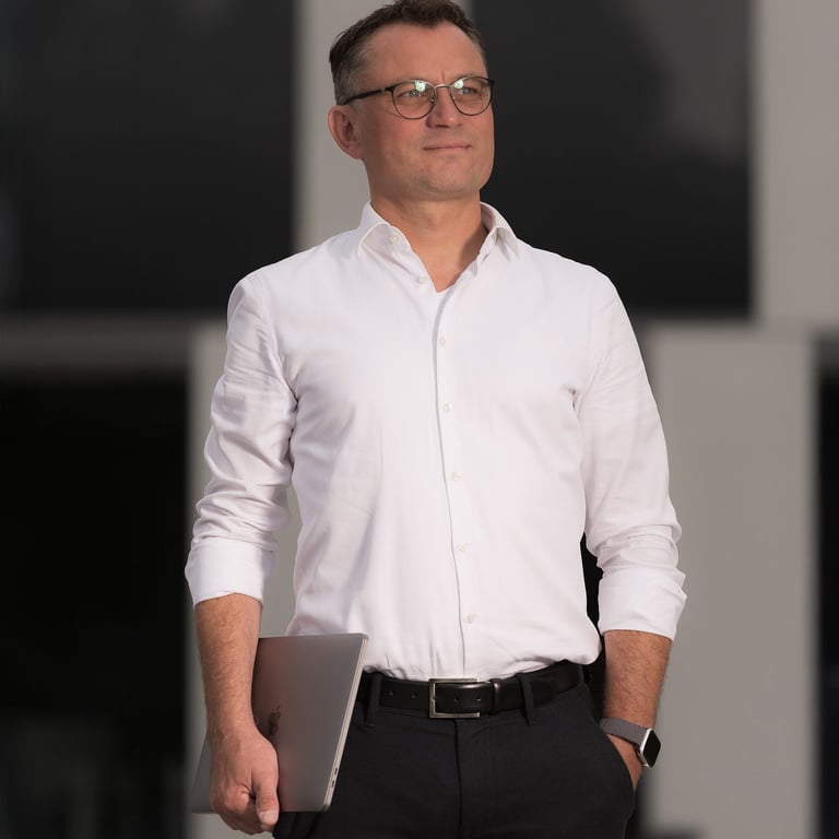 Unternehmer mit Laptop vor moderner Architektur in Oranienburg – Businessportrait bei Abendlicht