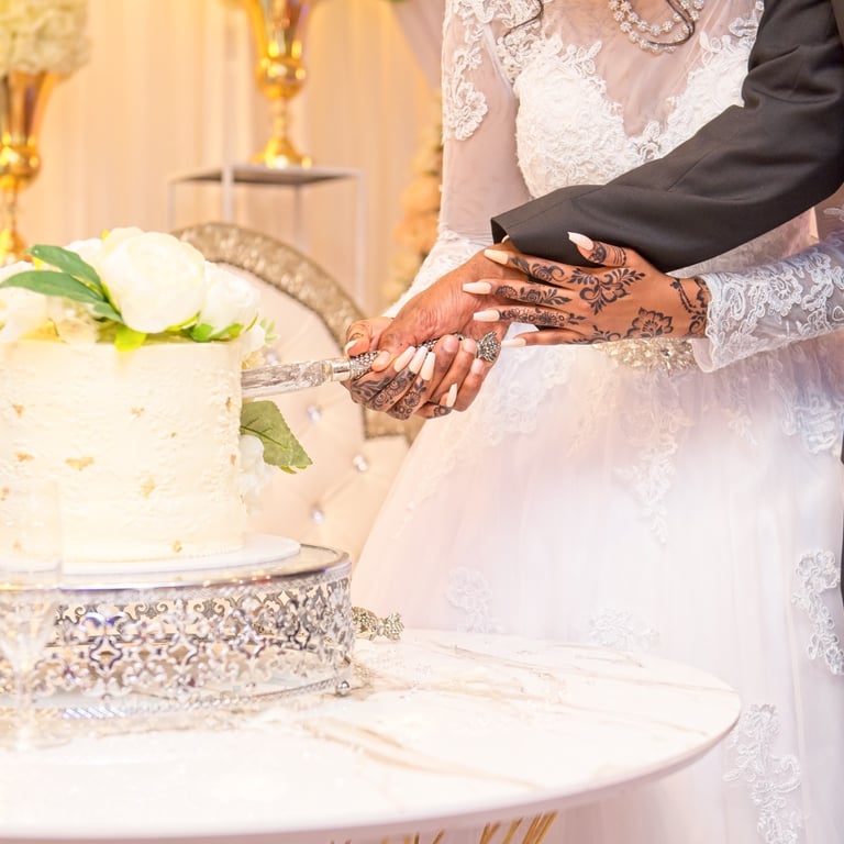 close up of bride and groom cutting wedding cake
