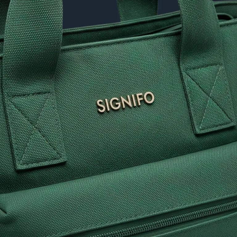 Close-up logo SIGNIFO metalik dan tekstur anyaman kanvas hijau pada tas.