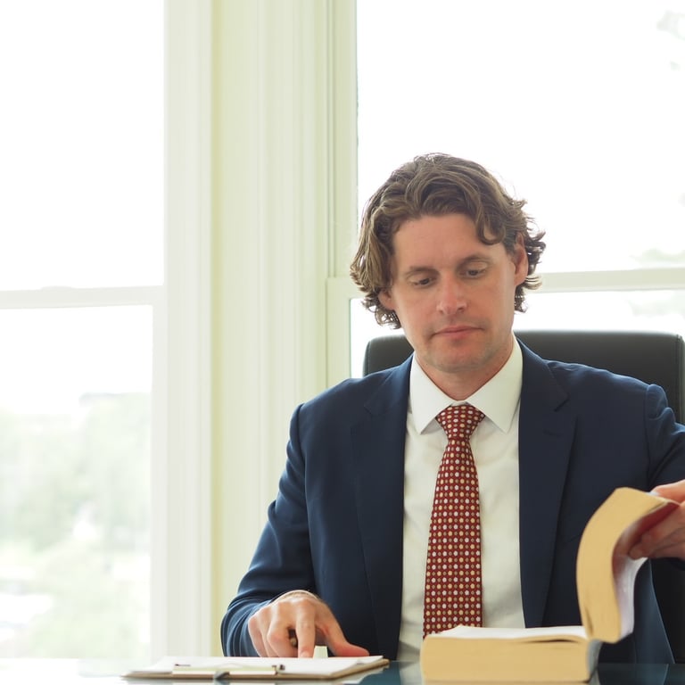Little Rock DWI Attorney Kale Ludwig reads DWI statutes in Homard House office. 