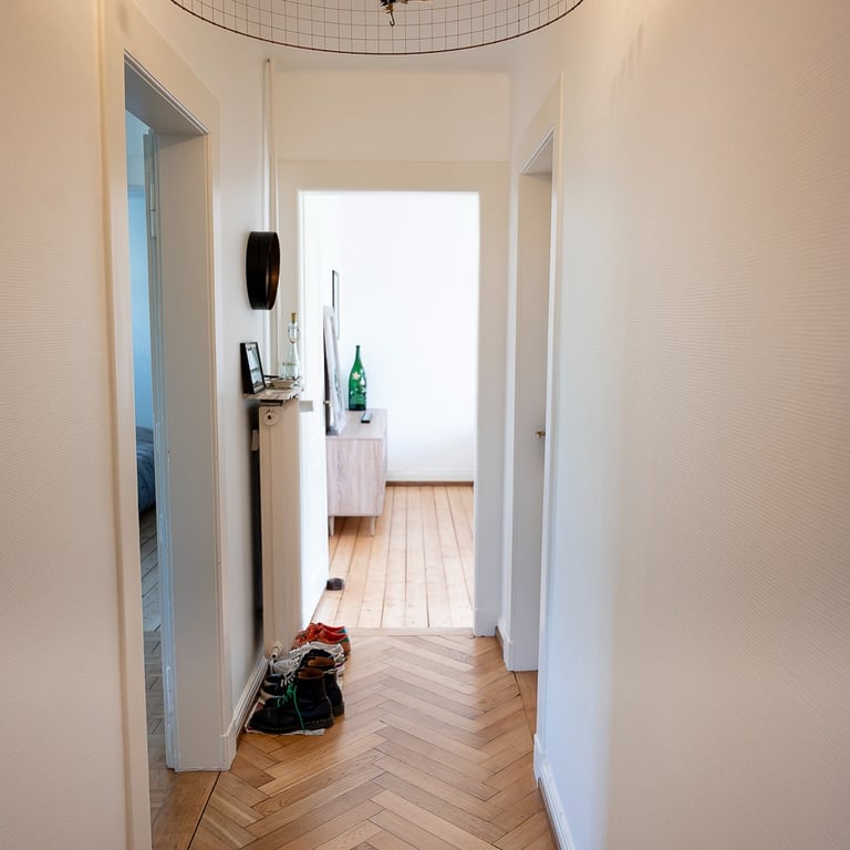 couloir distribuant les pièces d'un appartement chaleureux avec luminaire Suspension Volière de Mathieu Challières
