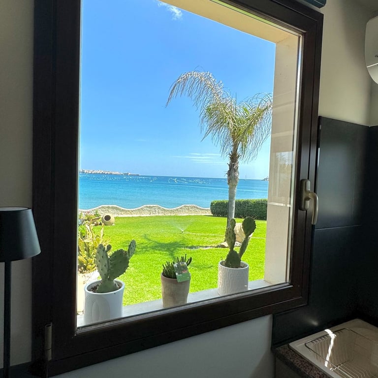 Panoramic sea view from kitchen window with palm tree and garden in Siracusa, Sicily villa