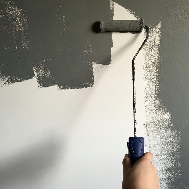 Ouvrir qualifié : rouleau de peinture gris sur un mur blanc