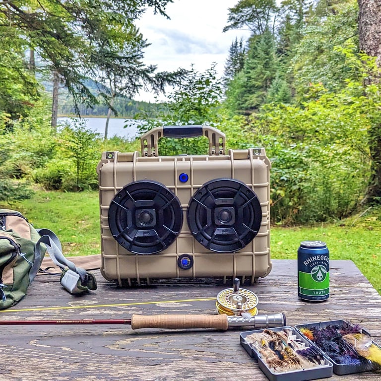 chillantix adventure boombox on a table with fly fishing gear and a nice cold Truth IPA