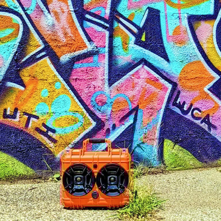 sweet orange chillantix advernture boombox by a graffiti wall.
