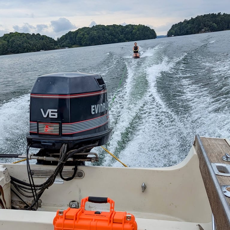 awesome chillantix boombox in a boat with a girl kneeboarding and likely listening to kid rock