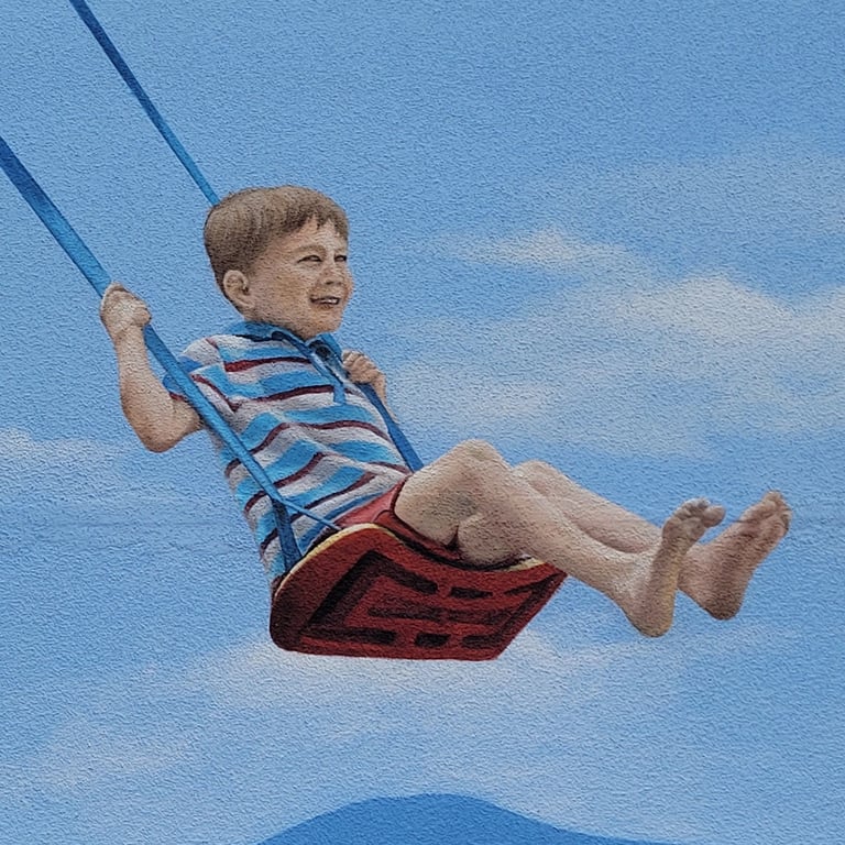 Détail d'une fresque murale: un garçon joue sur une balançoire. Viry, Jura (39).