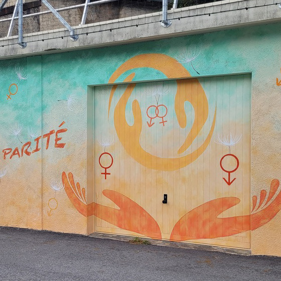 Eléments d'une fresque peinte sur une façade, des symboles et des mains colorés