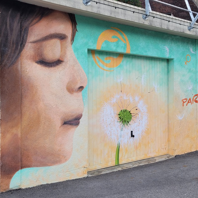 Fresque extérieure peinte, représentant un enfant souflant sur un pissenlit.