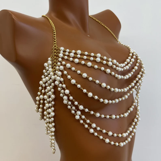 A chest piece made of many strings of pearls on gold chains.
