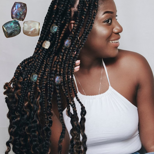 Woman with box braids displaying her jewel hair beads.