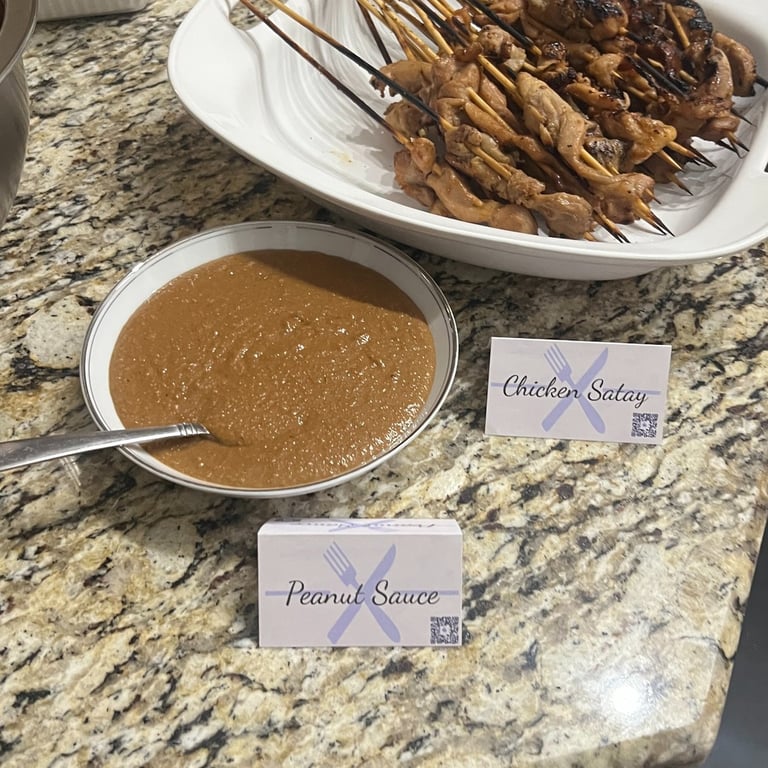 Platter of Chicken Skewers with a bowl of peanut sauce sitting on a counter