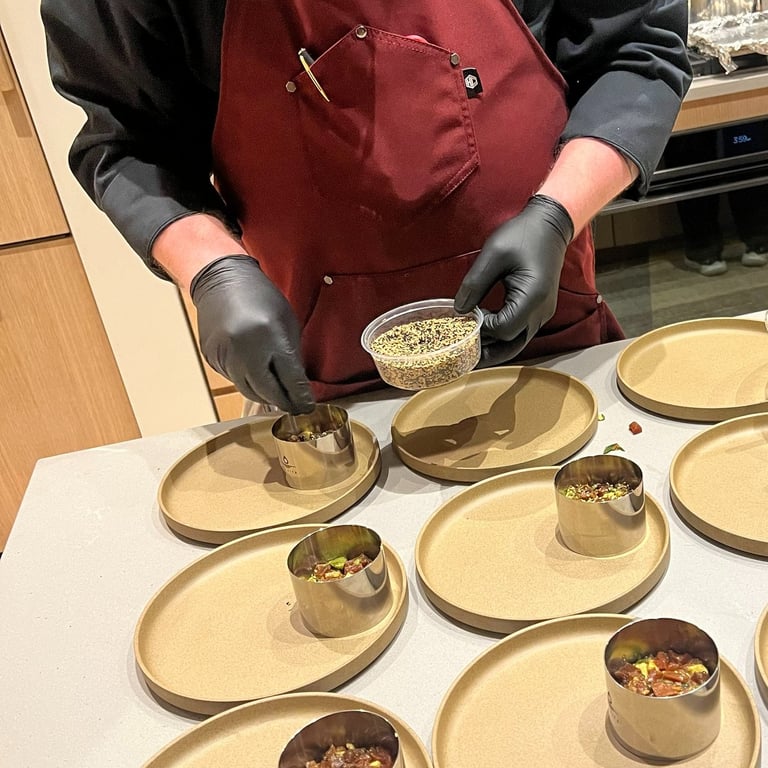 sprinkling the tuna tartare with toasted sesame seeds