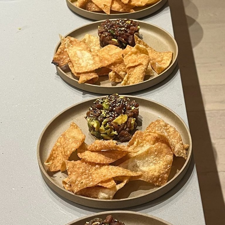 row of plated tuna tartare with fried wonton chips