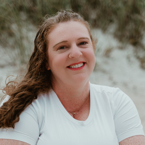 Dr. Anna Abbott headshot in white shirt with beach background