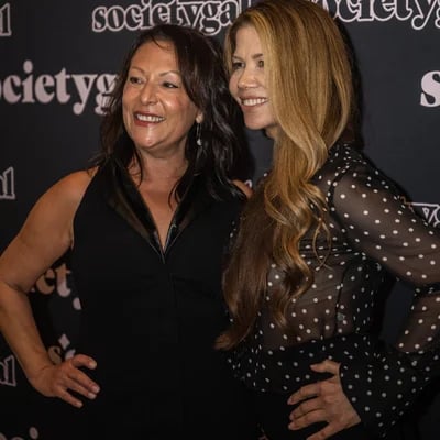two women standing next to each other on a red carpet event planner
