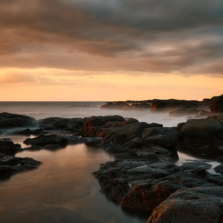 Long exposure shot of rocky shoreline at sunset in Albion, Mauritius, with dramatic clouds over the ocean