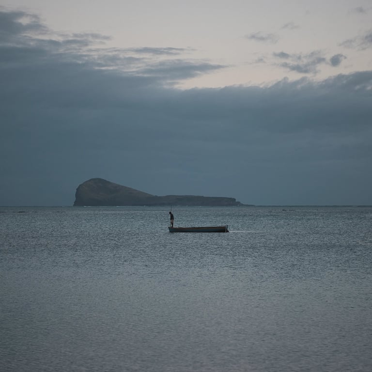 Solitary boat on calm waters with Coin de Mire Island in the background, Mauritius