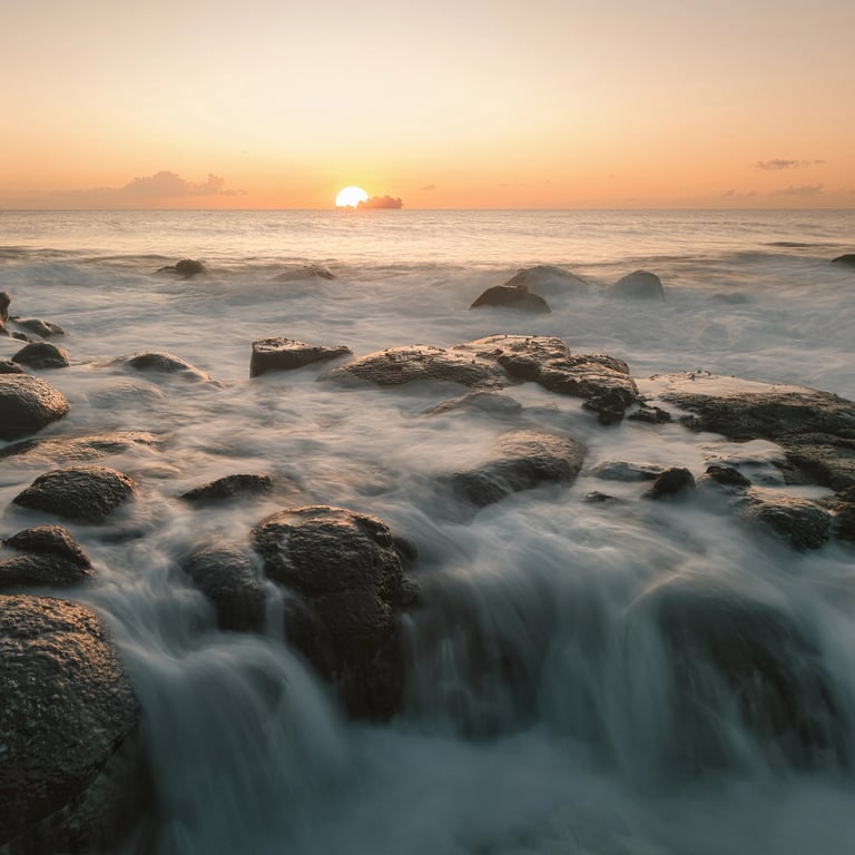 Sunrise over ocean waves on rocky shores in Albion, Mauritius