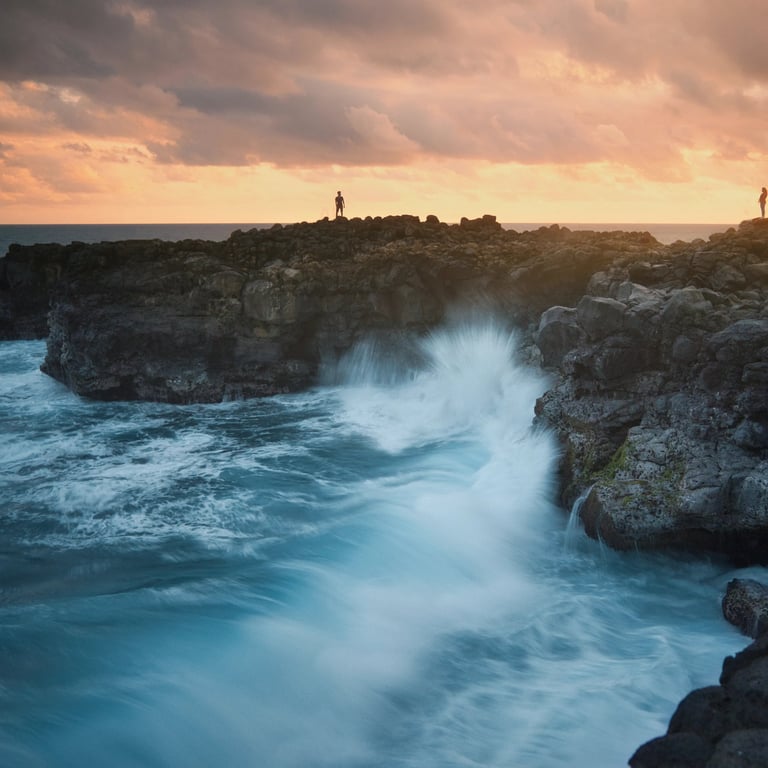 Waves crashing against rocky cliffs at sunset in Le Souffleur, Mauritius, with silhouetted figures on the coast