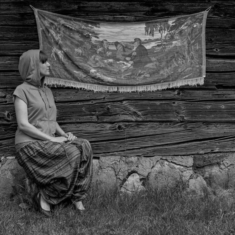 A woman sitting in front of a wall with a painting on it