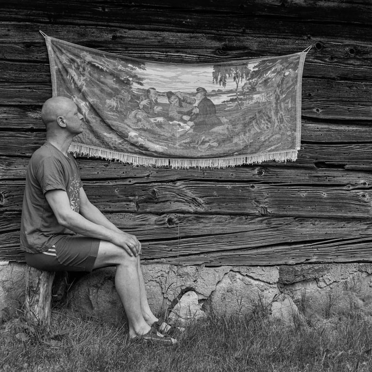 Man sitting on bench next to the wall painting