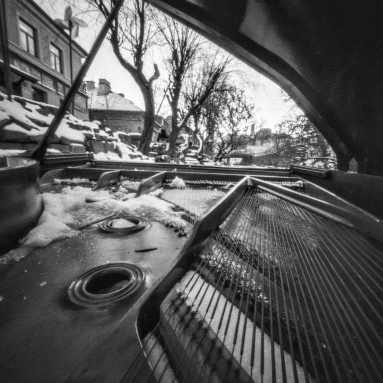 Open piano standing on the winter street with opened deck