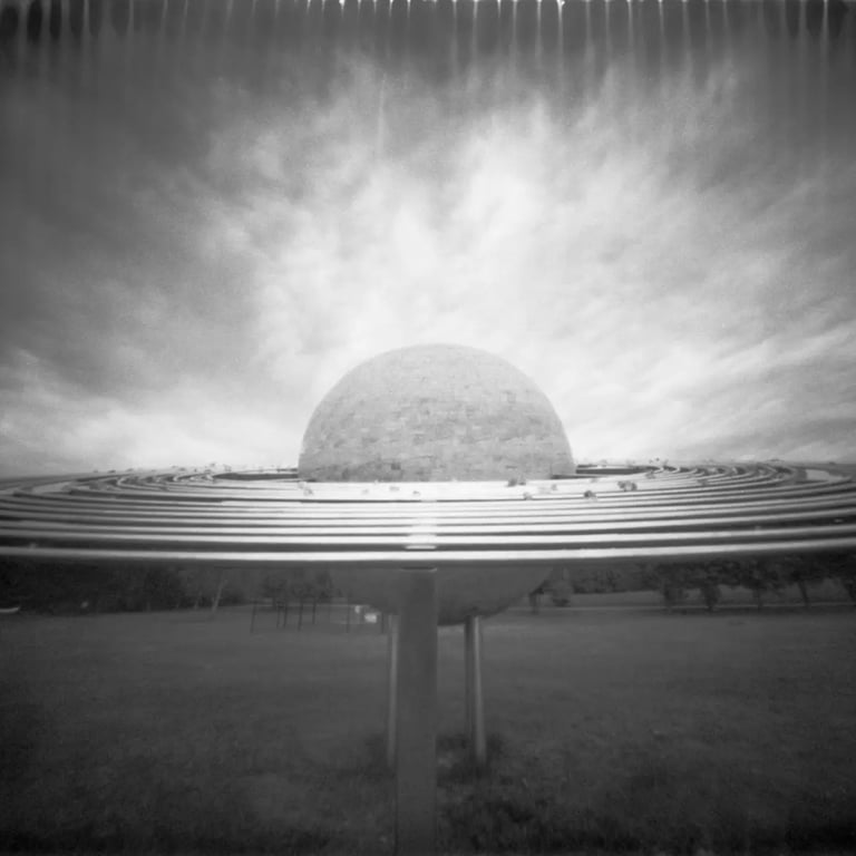 Black and white pinhole picture of a massive orb in the sky.