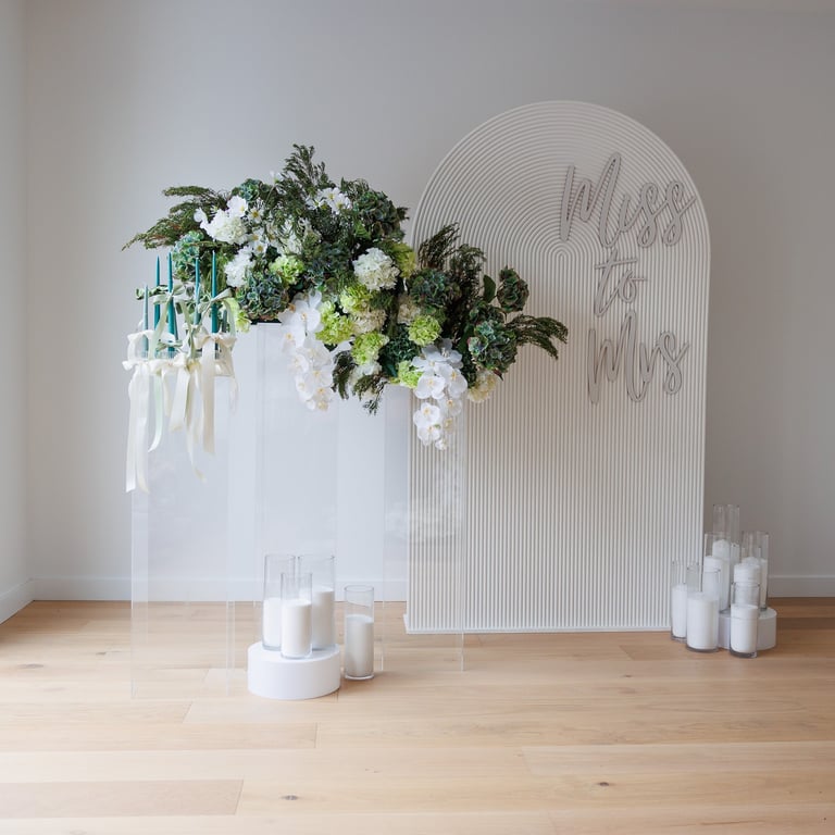 a vase with flowers and candles on a wooden floor