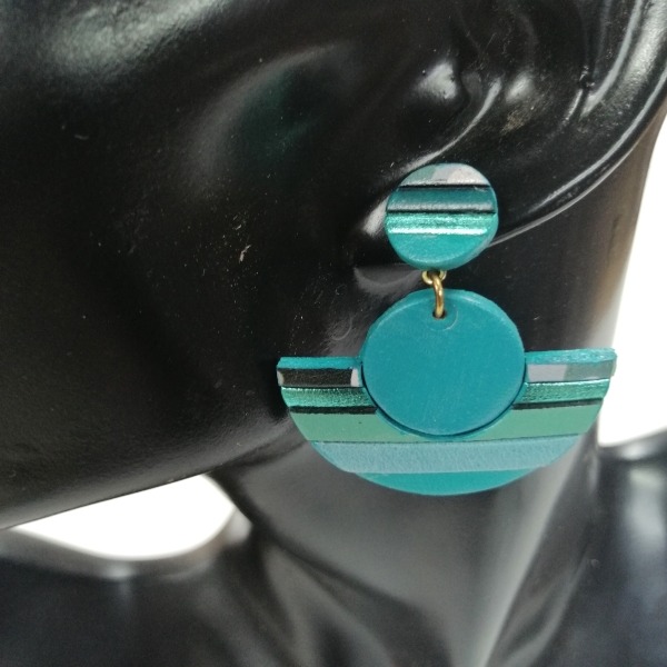 a woman's earring with a blue and green earrings