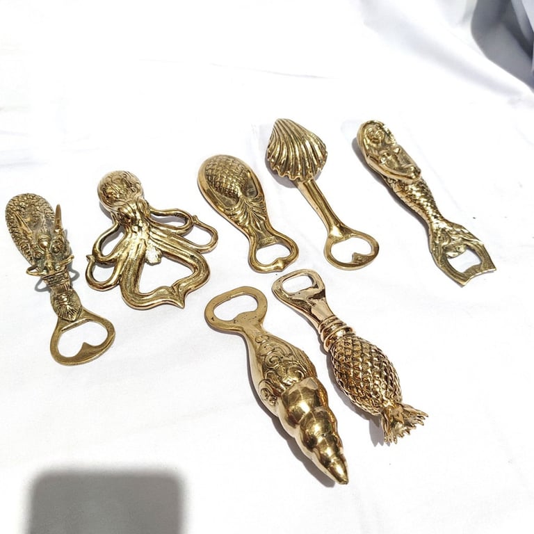 a bunch of gold colored metal objects on a white surface