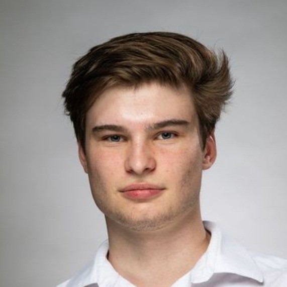 a man with a very short haircut and a white shirt