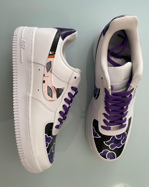 Nike Air Force 1 personalizzate anime con dettagli viola e neri e illustrazione di occhi sul pannello laterale.