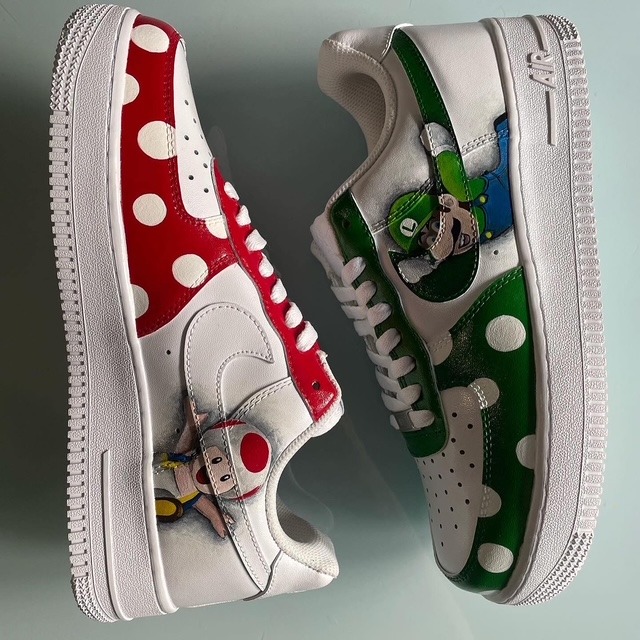 Nike Air Force 1 personalizzate rosso e verde con pois bianchi e grafiche ispirate ai videogiochi, viste dall’alto.