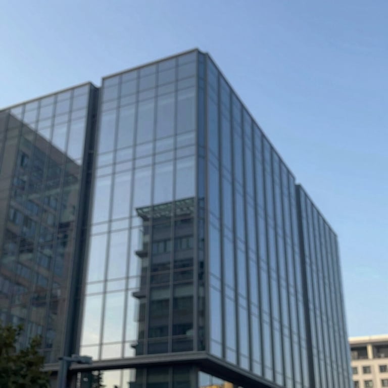 An architectural shot of a modern glass building reflecting a clear sky, symbolizing vision and refinement using #BCCAD6 tones.