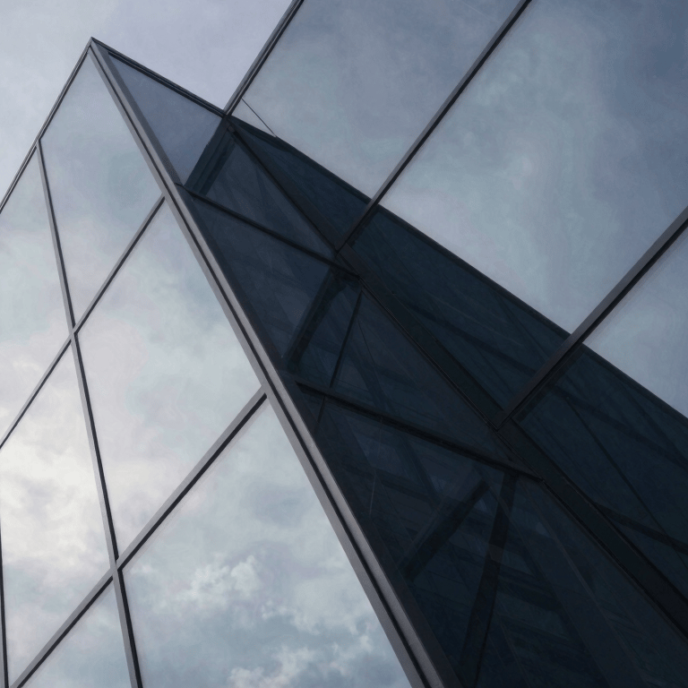 Professional photographer's eye view of a hand holding a high-end smartphone with a blurred city background. The phone screen reflects soft Pale Mist light.