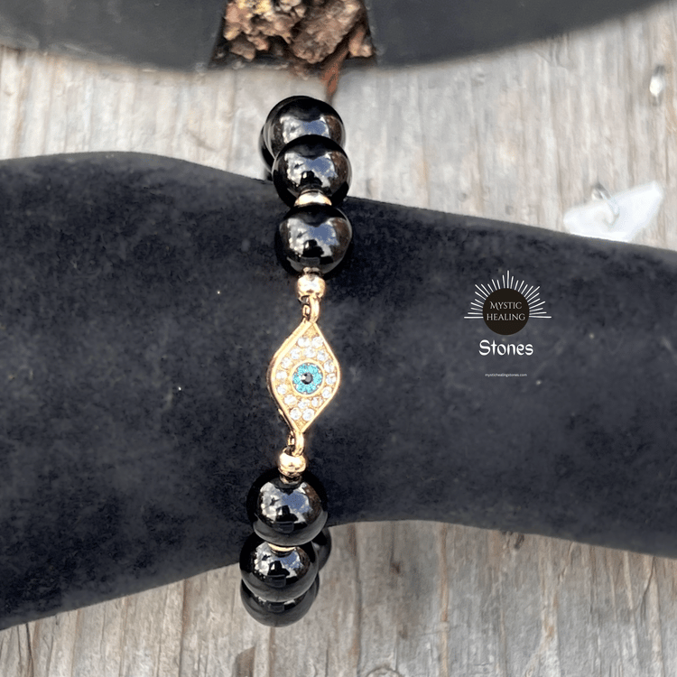 Obsidian beaded evil eye bracelet with gold accents and sparkling crystals for spiritual protection.