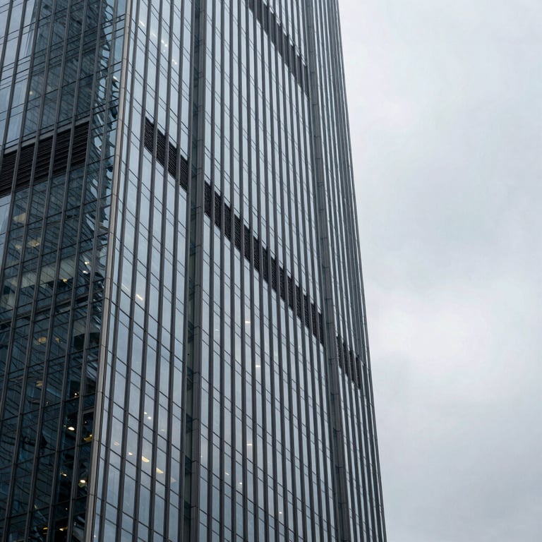 An architectural shot of a modern glass skyscraper in an International / Global financial district, reflecting a Mist Grey sky.
