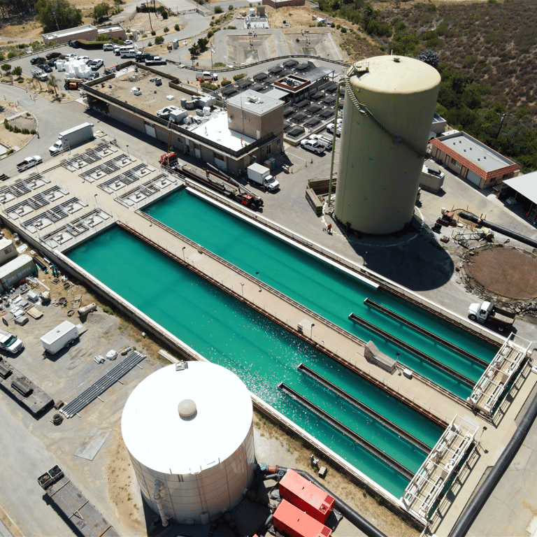 Aerial view; large water treatment or industrial processing facility with treatment ponds, storage tanks, and infrastructure