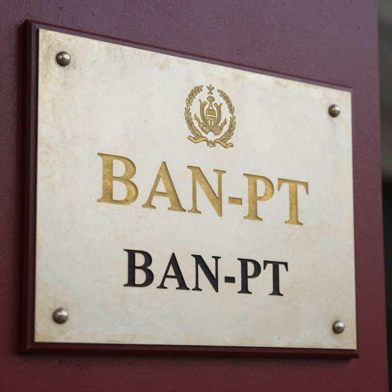Close-up of an official BAN-PT accreditation plaque mounted on a maroon institutional wall, gold lettering clearly visible, natural ambient lighting, no people, formal and authoritative