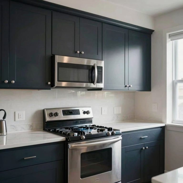 A sleek, modern kitchen in a North American / US condo, featuring stainless steel appliances and dark navy cabinetry under bright, natural light.