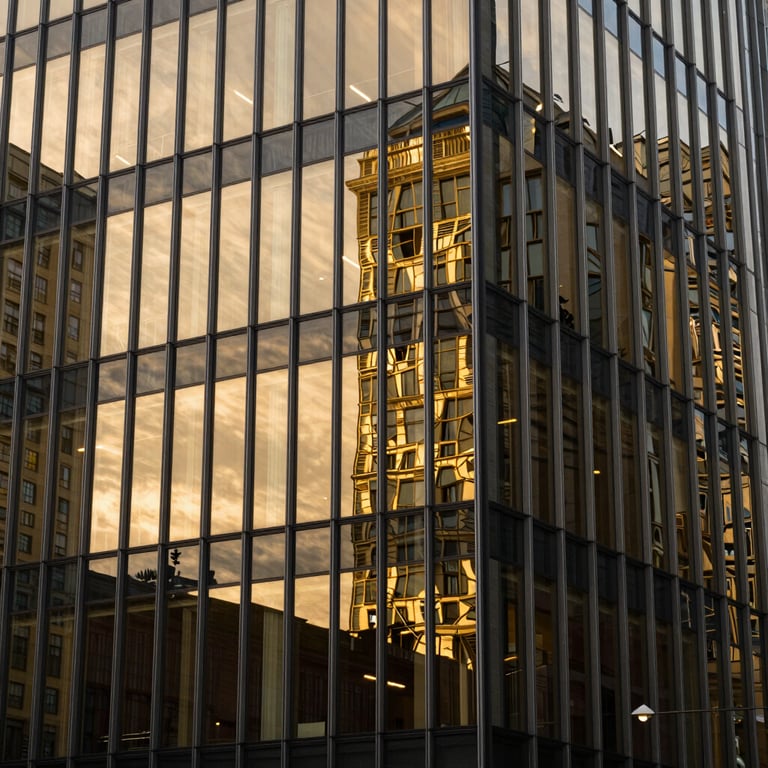 Abstract photography of a modern building facade with gold and dark glass reflections.