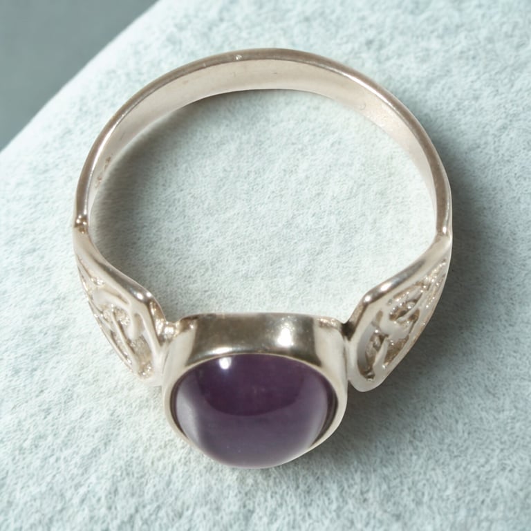 Handcrafted silver Celtic ring featuring a round purple amethyst cabochon gemstone.