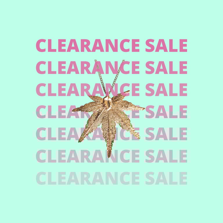 Gold maple leaf pendant necklace on a mint background with pink clearance sale text overlays.